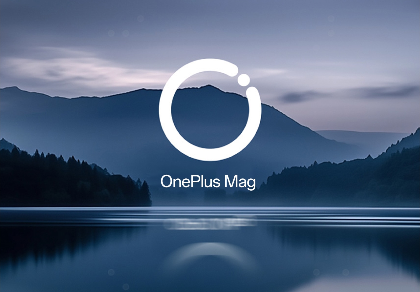 Serene mountain landscape with a calm lake and the OnePlus Mag logo in the center.