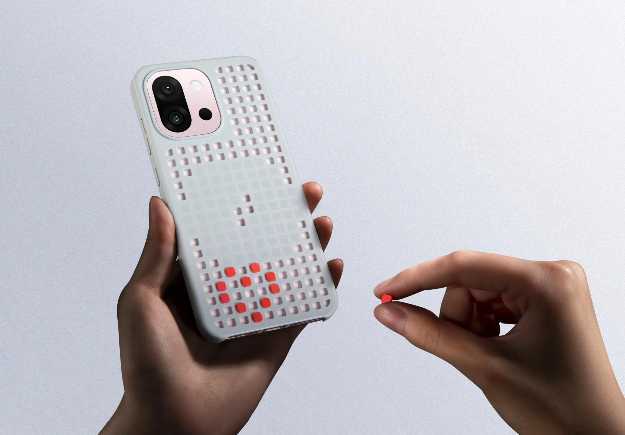 White phone case with red dots, held in hands against white background.