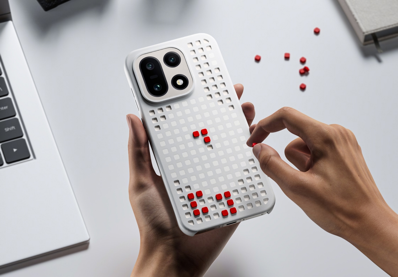 A white smartphone case with a perforated pattern and red accents.